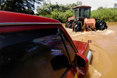 Hitched to a tractor, our SUV taxi is towed across a rapid river.