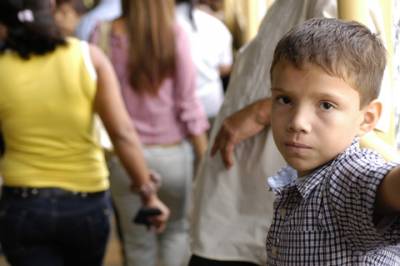 Inside the Gran Terminal del Caribe, San Jose’s bus station to the Caribbean coast, a boy waits with his father to board a coach.
