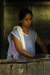 A women prepares a meal inside a soda in Cahuita.