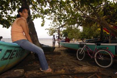 A girl watches as the costal life of Puerto Viejo happens around her.