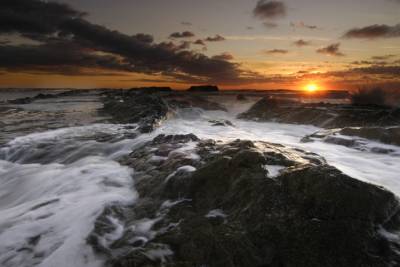 A foamy wave breaks the rocks.