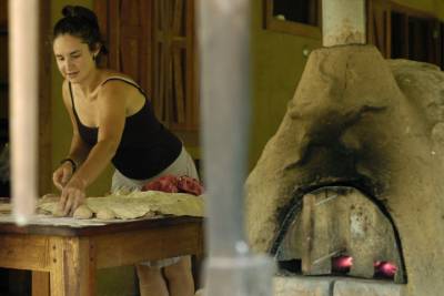 Anna prepares loaves of uncooked bread for the oven