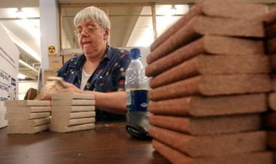 Goodwill employee Joani Reese puts labels on samples of Weyerhaeuser decking-- an example of assembly work done in the Contracts Department of the Commercial Services Division of Goodwill Industries of Tacoma.
