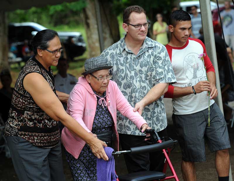 Guam's Lt. Gov. Ray Tenorio walks with Ana San Nicolas Ungacta to place a flower in honor of her brother, David Sablan San Nicolas, a victim of the 1944 Chagui'an Massacre. Annually there is a memorial in Yigo, Guam, to remember the ÒForgotten 45,Ó who were killed by the Japanese in WWII. After the war the island was seized by the U.S. as a territory and used as a hub in the Pacific for submarines, jets and naval fleet vessels. The islanders want to see a smaller military presence on the tiny island which has 160,000 residents. (Tiffany Tompkins-Condie, McClatchy.)