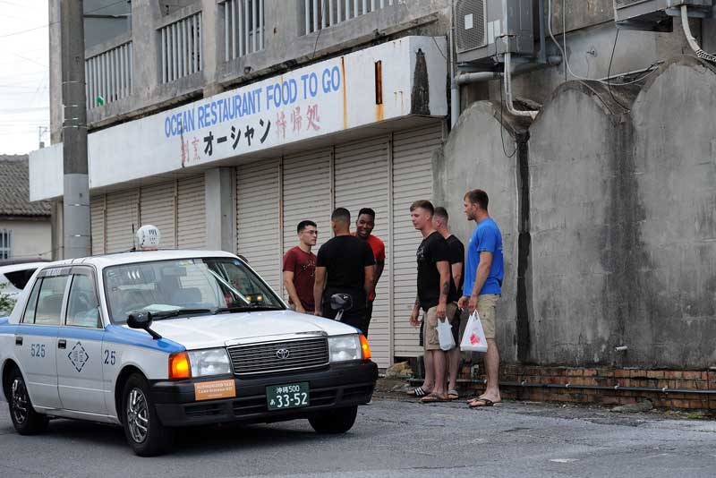 Marines from nearby Camp Schwab arrive by taxi at Ocean Sushi Restaurant in Henoko, Okinawa, where most of the eatery's business comes from military customers. Though the tiny village welcomes Americans, daily protests outside the camp's gates have become the norm as local residents and international activists protest plans to build airstrips in Oura Bay. (Tiffany Tompkins-Condie, McClatchy.)