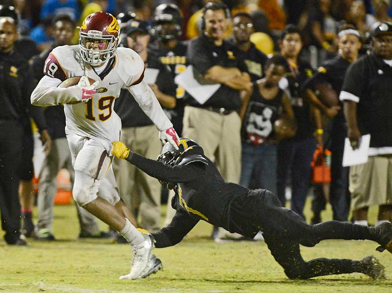 Clovis West’s Caleb Kelly, left, finds room up the sideline before being tackled at McLane High stadium. (Fresno Bee file.)