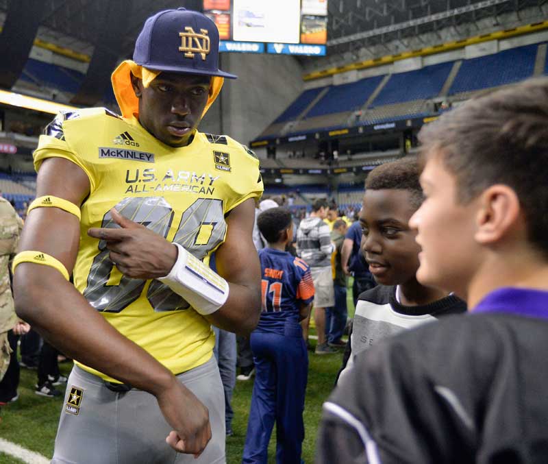 West wide receiver Javon McKinley, left, gives his armbands to a fan after the Army All American Bowl against the East. (AP file.)
