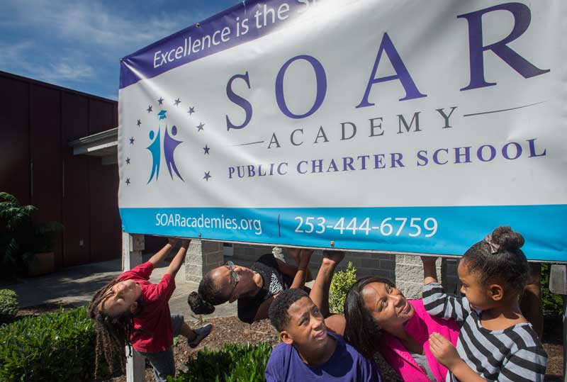 Roquesia Williams with her children, from left, Gesiah, 6, Geharii, 11, Genai, 14, and Gervais, 4, visiting SOAR Academy in Tacoma on Tuesday. Williams’ three oldest children will each attend one of Tacoma’s three new charter schools opening in August. (Lui Kit Wong, staff photographer.)