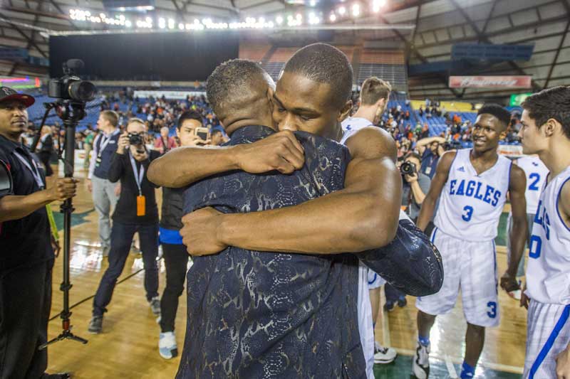 Viont'e Daniels hugs coach Jerome Collins after Federal Way beat Davis 65-46 to win the WIAA 4A boys basketball championship in March. (Peter Haley, staff file.)